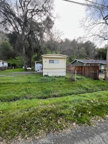 a view of a house with a big yard and large trees