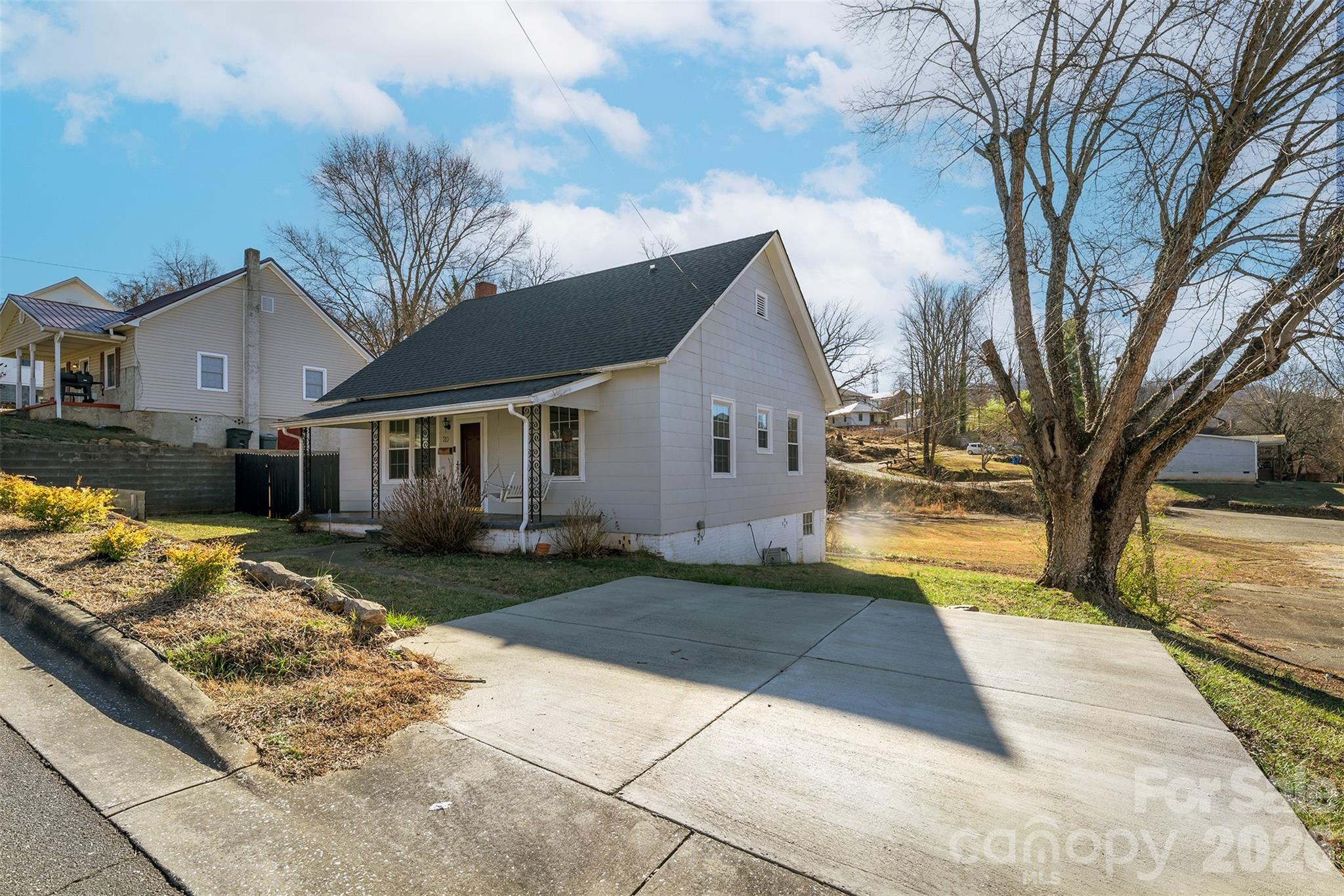 20 1st Street Marion, NC 28752 - Photo 22 of 23 a view of a white house next to a yard with a large tree