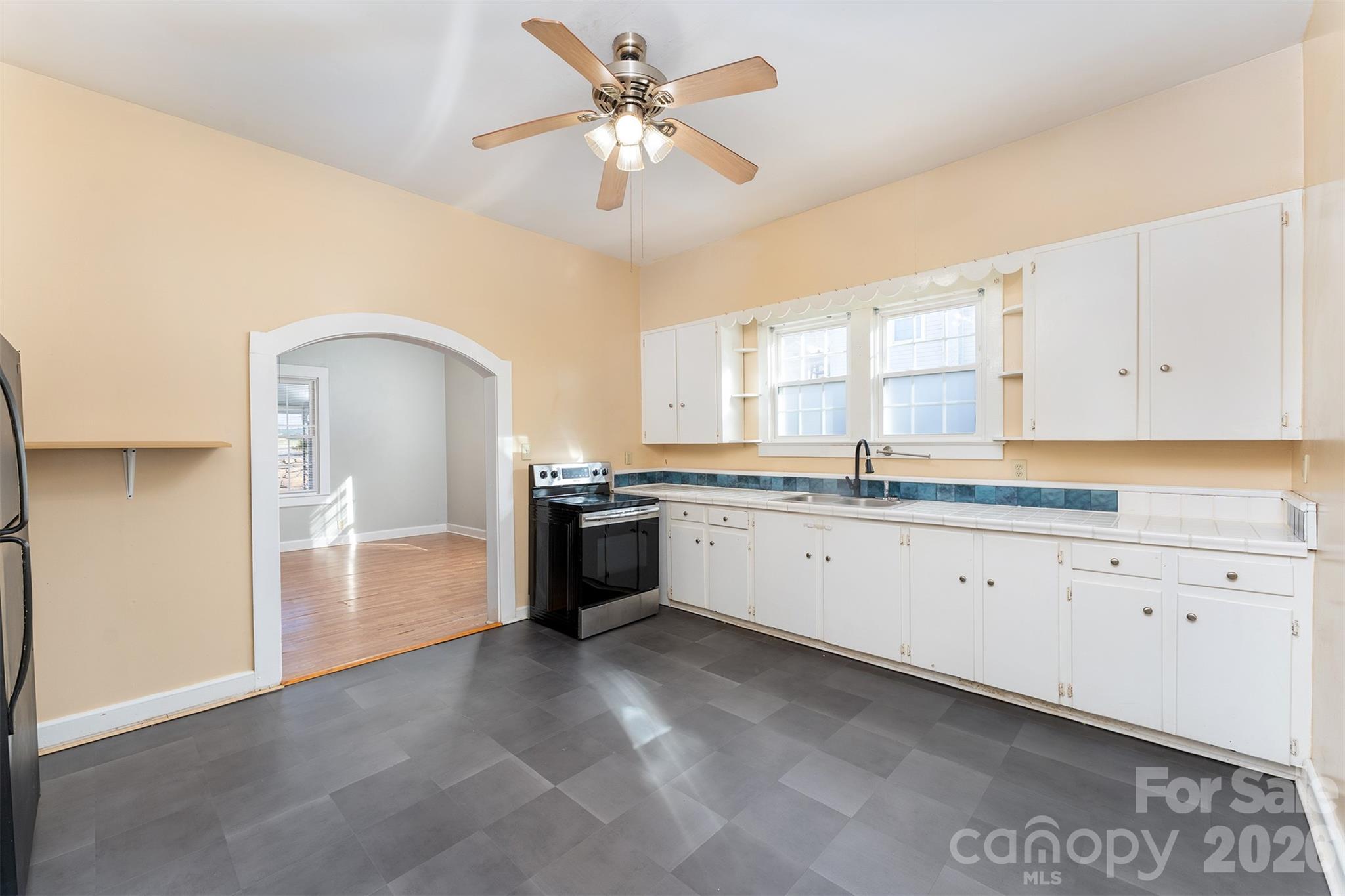 20 1st Street Marion, NC 28752 - Photo 10 of 23 a large white kitchen with granite countertop a stove a sink a window and a dining table