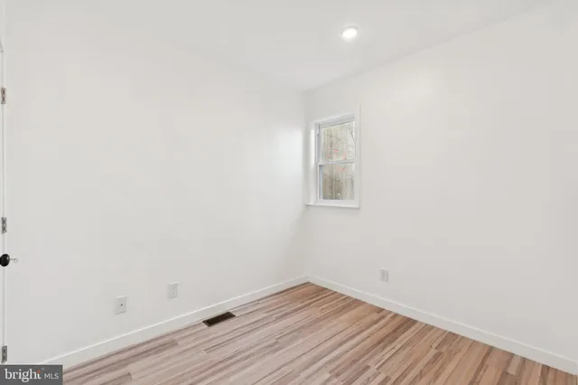 a view of a room that has wooden floor and white walls