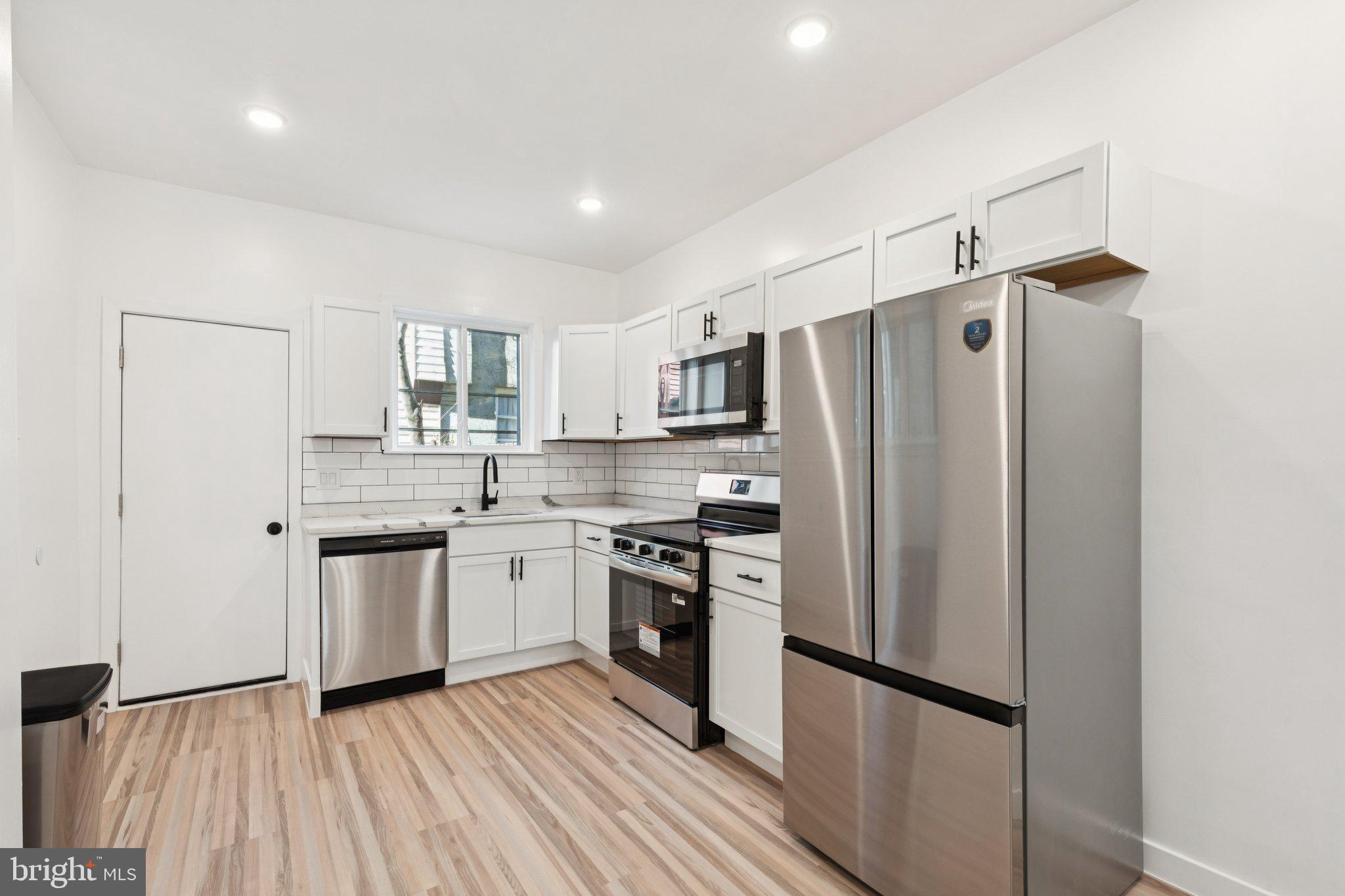2242 South Bonsall Street Philadelphia, PA 19145 - Photo 4 of 21 a kitchen with stainless steel appliances a refrigerator sink and microwave