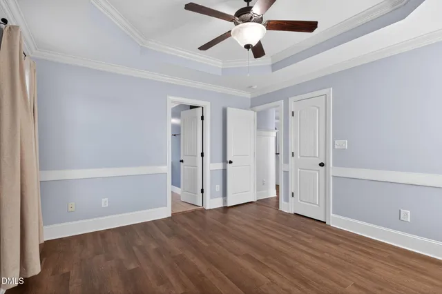 an empty room with wooden floor and ceiling fan