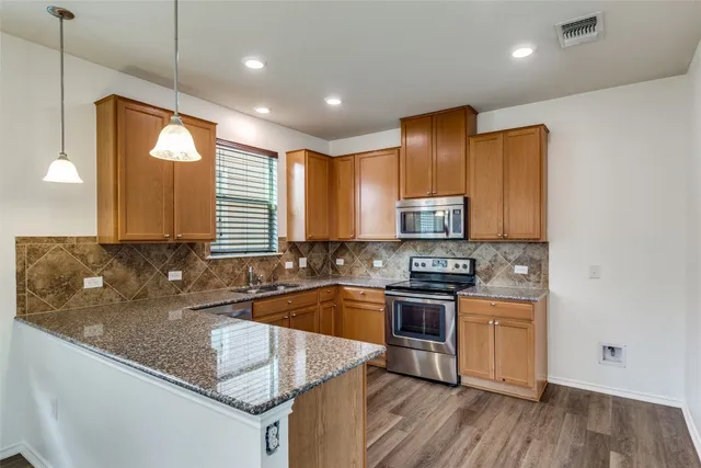 a kitchen with stainless steel appliances granite countertop a sink stove and cabinets