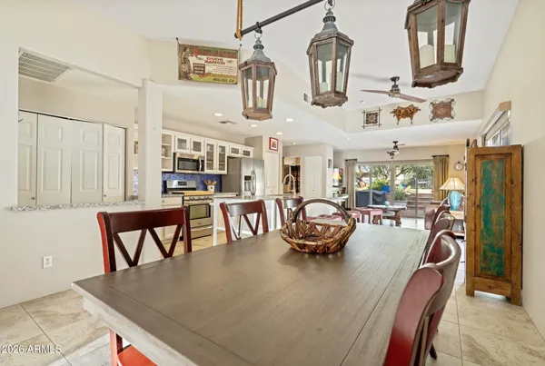 a view of a dining room with furniture a kitchen and chandelier