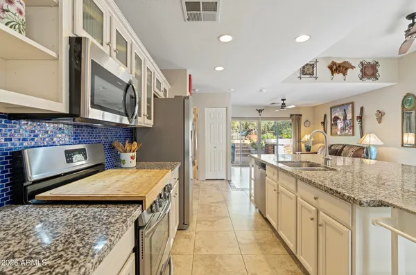 a kitchen with stainless steel appliances granite countertop a sink and a stove