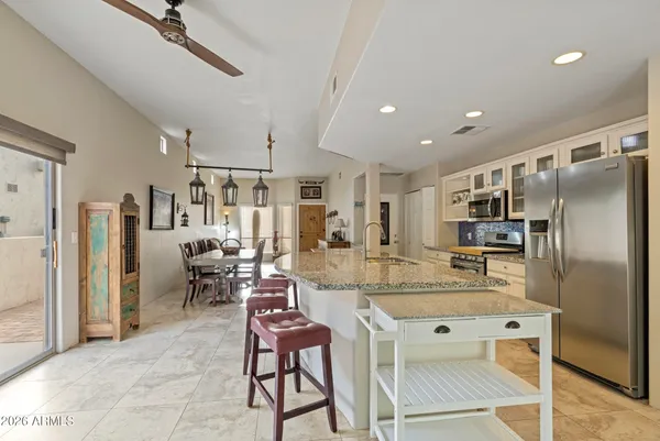 a kitchen with stainless steel appliances kitchen island granite countertop a refrigerator and microwave