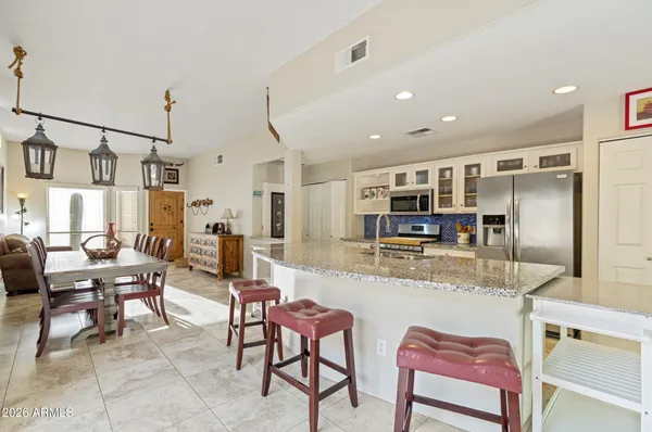 a kitchen with stainless steel appliances kitchen island granite countertop a table and chairs