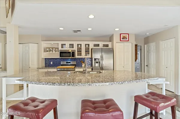 a kitchen with stainless steel appliances granite countertop a sink and a refrigerator