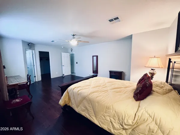 a bedroom with a bed and wooden floor