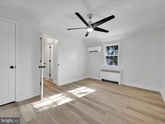 a view of empty room with wooden floor and window