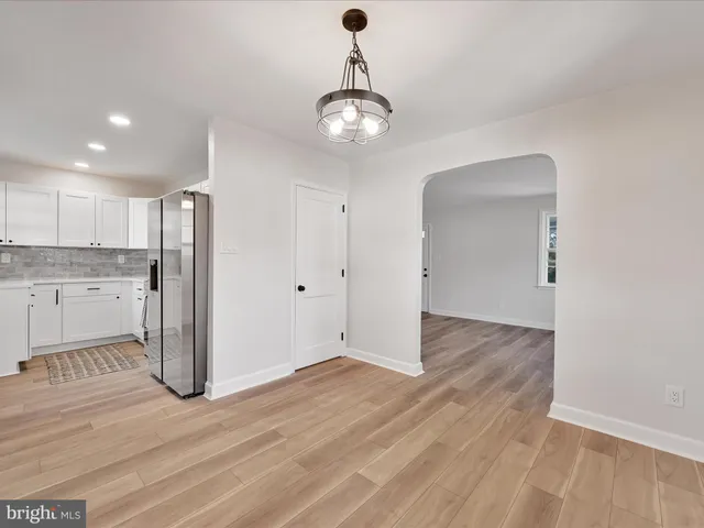 a view of a kitchen with wooden floor and a ceiling fan