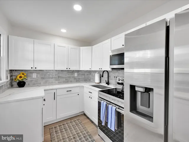 a kitchen with stainless steel appliances a stove a sink and a refrigerator