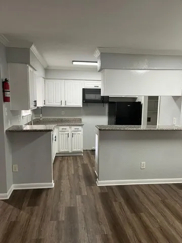 a kitchen with stainless steel appliances granite countertop a stove a microwave a sink and cabinets