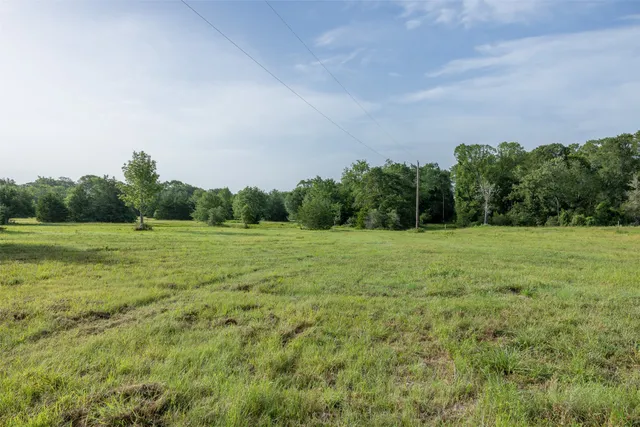 a view of a green field with wooden fence