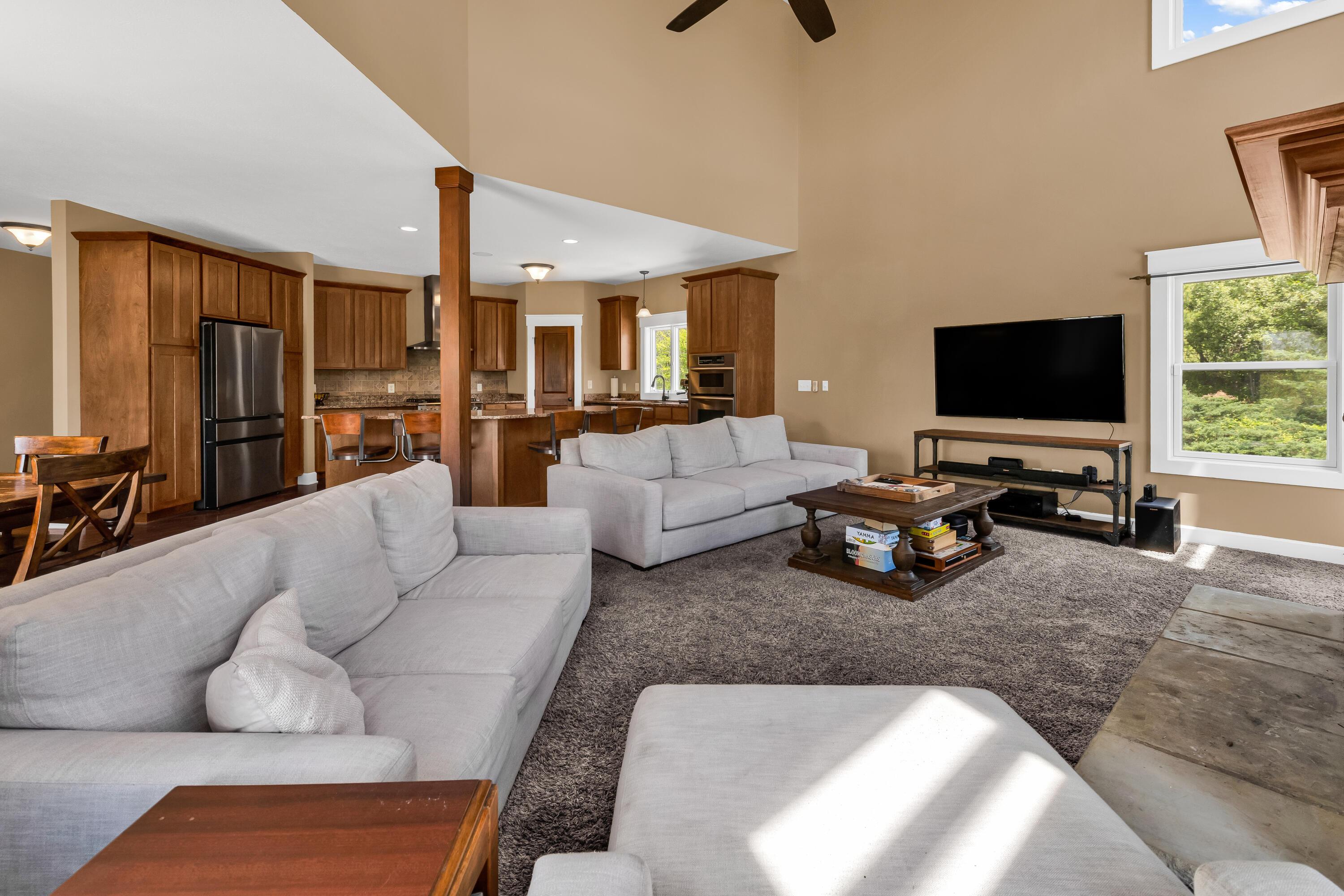 16689 Bailor Road Laurelville, OH 43135 - Photo 28 of 73 • Light sand carpet
• Tan painted walls
• Two story ceiling
• New lighted ceiling
fan ~ 2025
• Stone floor to ceiling,
woodburning fireplace
with raised hearth &
mantle