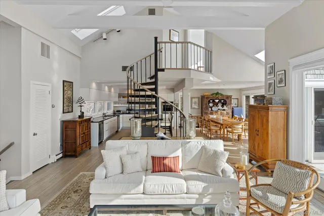 a living room with furniture kitchen view and a window