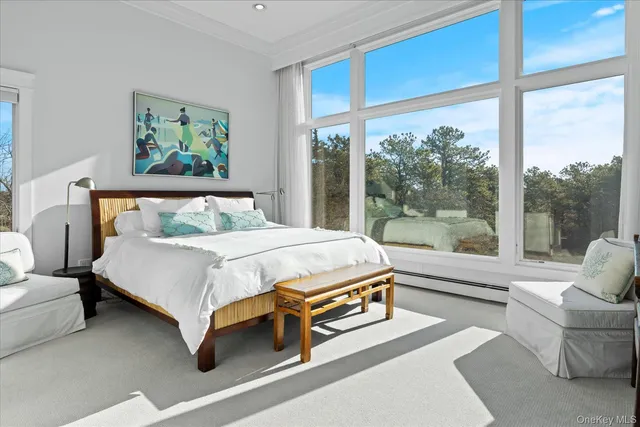 a bedroom with a bed and a large window with outer view