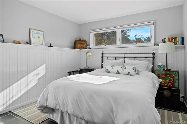 a bedroom with a bed and a painting on the wall