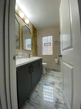 a bathroom with a sink a toilet and mirror