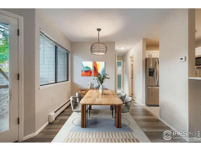 a dining room with wooden floor a chandelier a wooden table and chairs