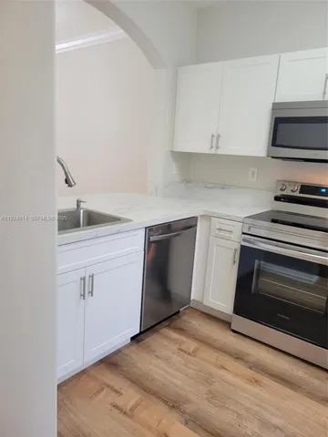 a kitchen with sink cabinets and stainless steel appliances