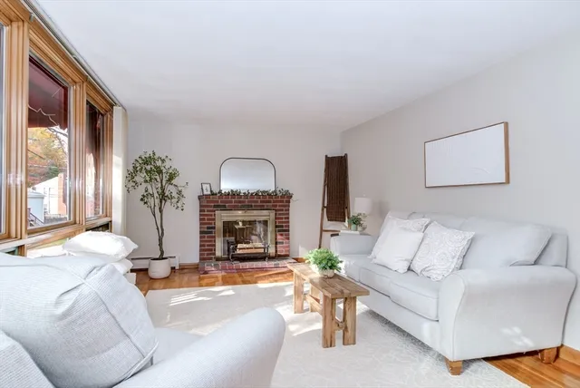 a living room with furniture a fireplace and a large window