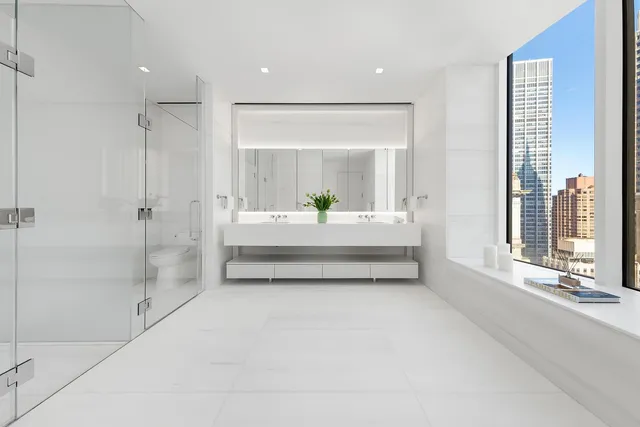 a bathroom with a white tub shower and window