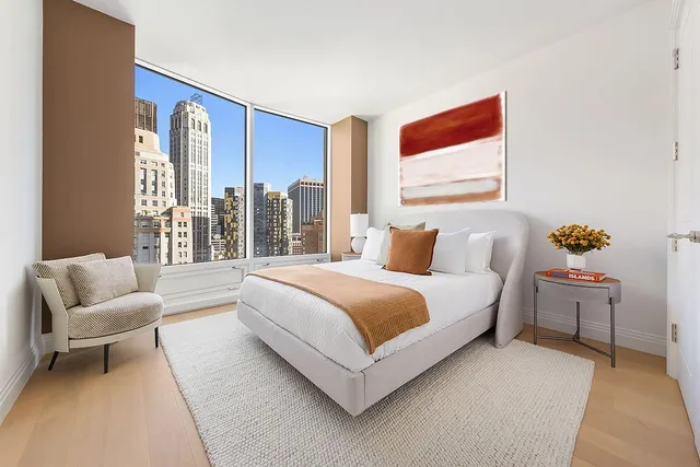 a spacious bedroom with a bed and glass window