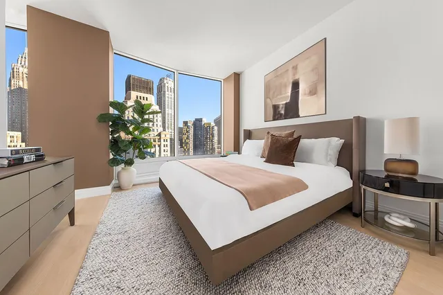 a bedroom with a bed and potted plant