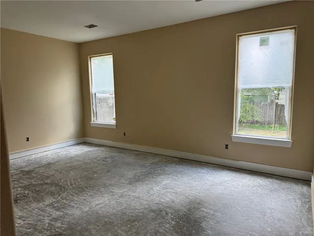 a view of an empty room with a window and chandelier