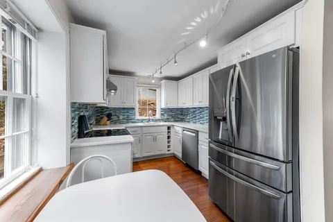 a kitchen with stainless steel appliances a refrigerator sink and cabinets