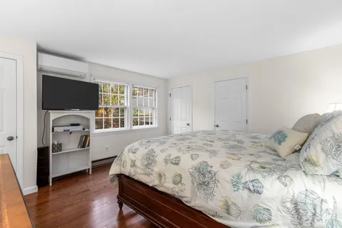 a bedroom with a bed and a flat tv screen on dresser
