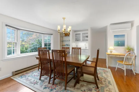 a view of a dining room with furniture a chandelier and wooden floor
