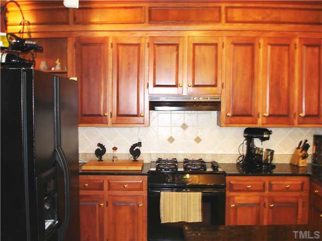 5505 North Hawthorne Way Raleigh, NC 27613 - Photo 3 of 12 Custom island kitchen features Italian tile backsplash, granite, recipe center, double pantry, entry from garage, tile floor, upgraded fixtures. Kitchen