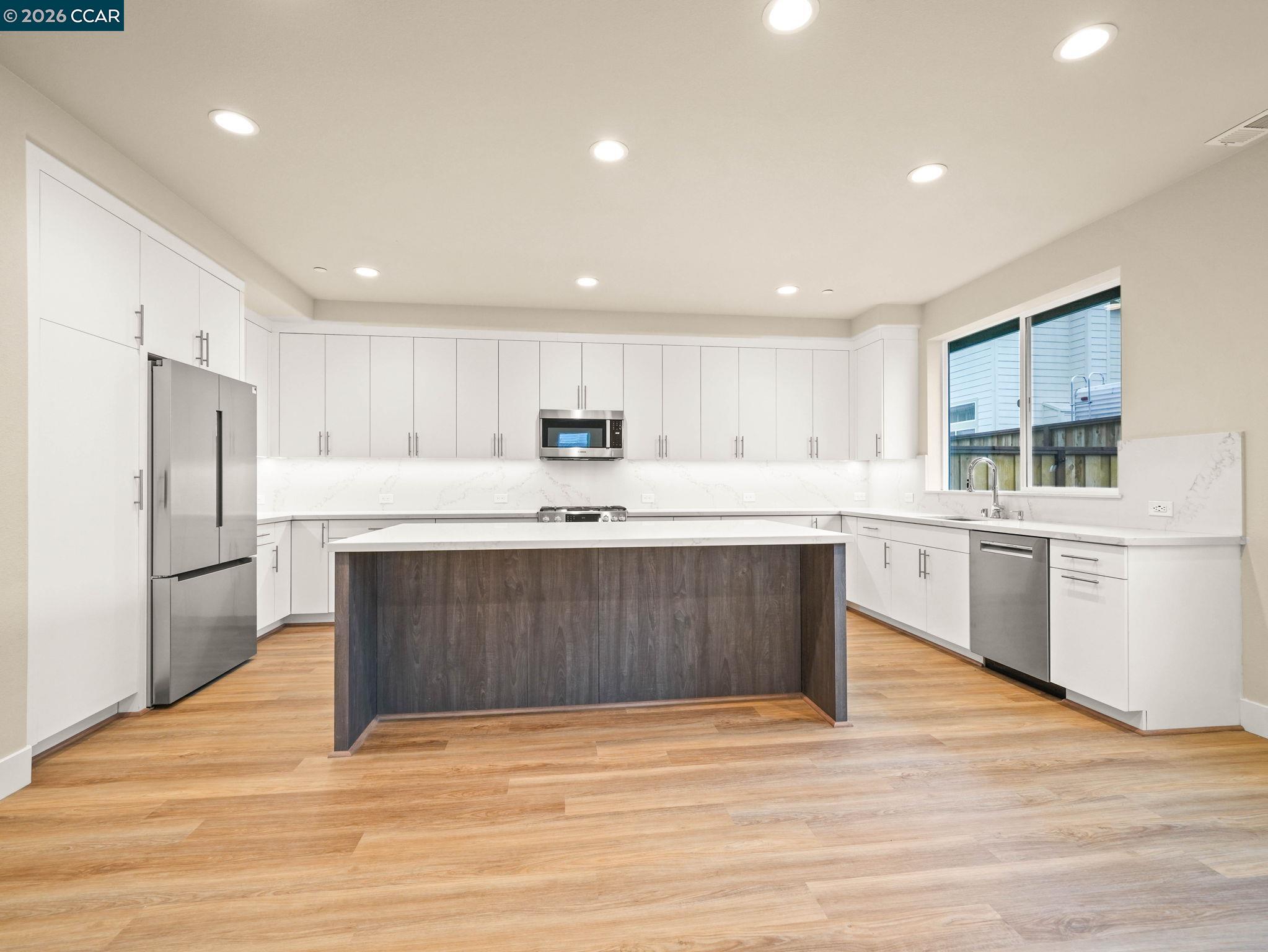 3030 Byron Road Tracy, CA 95377 - Photo 51 of 58 a kitchen with stainless steel appliances kitchen island granite countertop a refrigerator sink and white cabinets