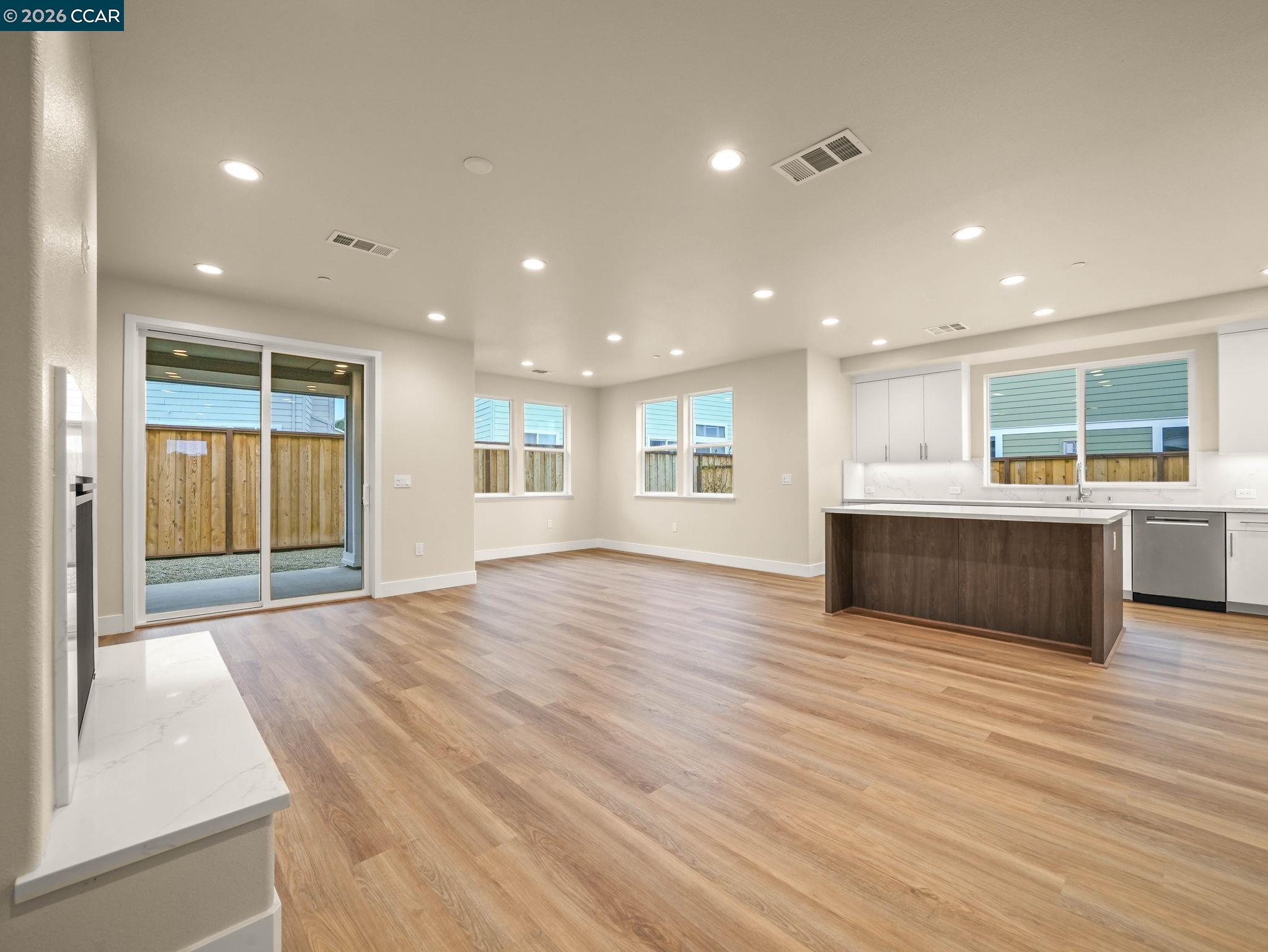 3030 Byron Road Tracy, CA 95377 - Photo 6 of 58 a view of kitchen and empty room with wooden floor and window