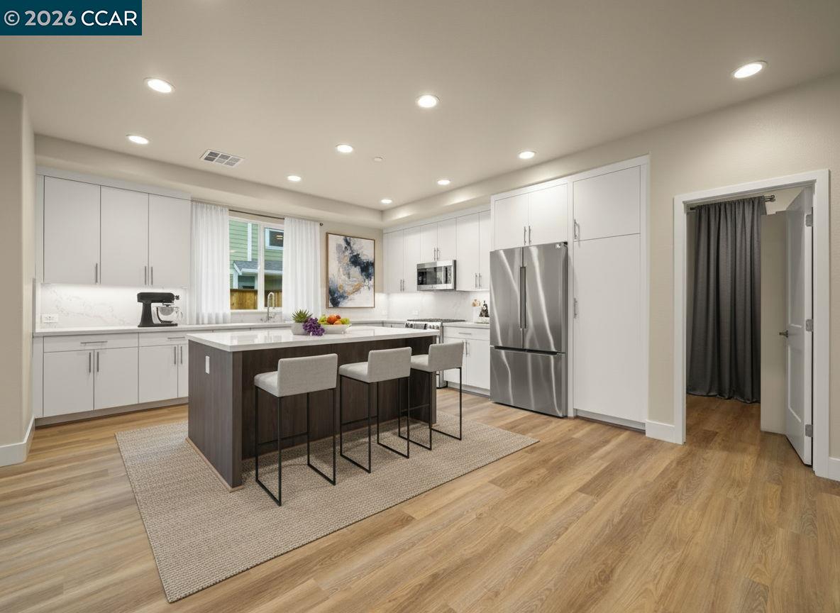 3030 Byron Road Tracy, CA 95377 - Photo 8 of 58 a kitchen with stainless steel appliances kitchen island granite countertop a refrigerator a stove a sink dishwasher and white cabinets with wooden floor
