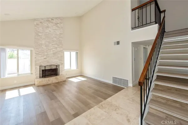 an empty room with wooden floor and fireplace