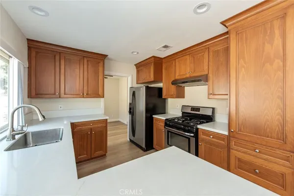a kitchen with granite countertop a refrigerator stove and sink