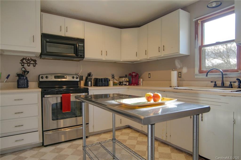 268 Painter Road Mill Spring, NC 28756 - Photo 11 of 41 a kitchen with stainless steel appliances granite countertop a stove a sink and a microwave