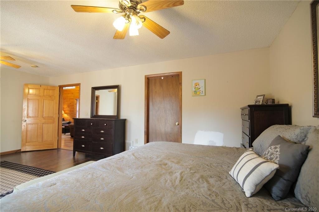 268 Painter Road Mill Spring, NC 28756 - Photo 14 of 41 a bedroom with a bed and a chandelier