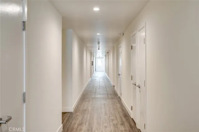 a view of a hallway with wooden floor
