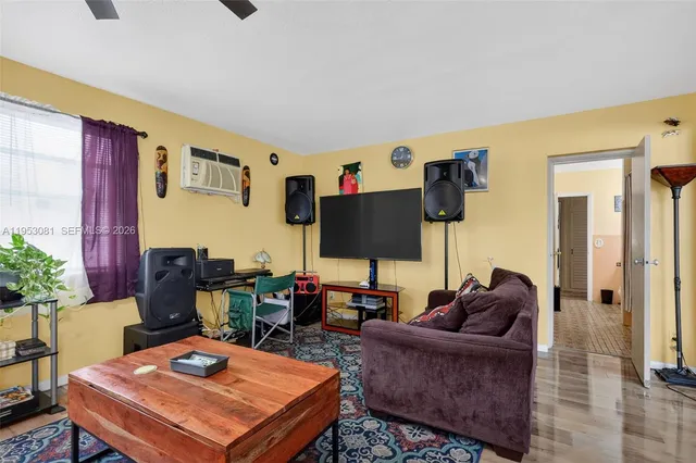 a living room with furniture a flat screen tv and a table