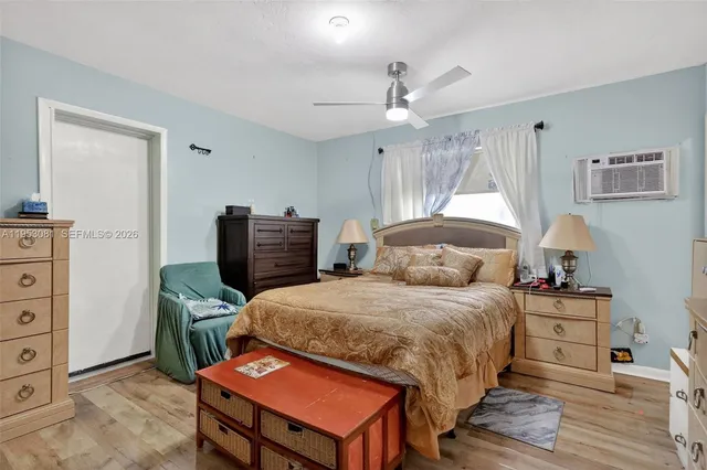 a bedroom with a bed a dresser and chair