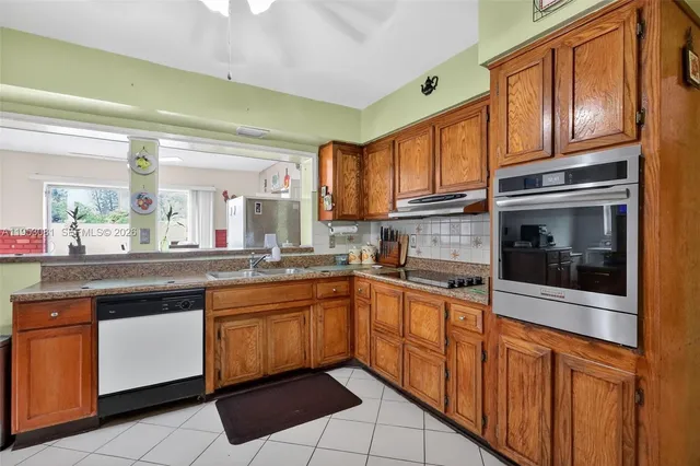a kitchen with stainless steel appliances granite countertop a stove microwave and cabinets