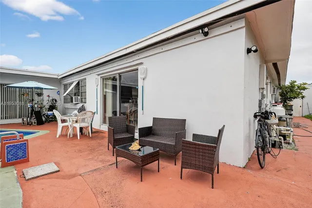 a vase of flowers sitting on a table with potted plants