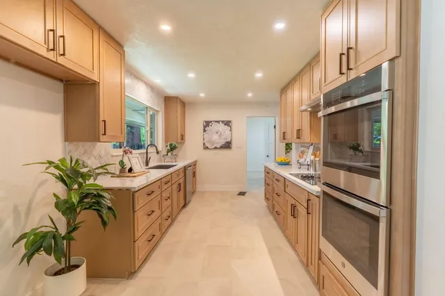 a large white kitchen with a large window