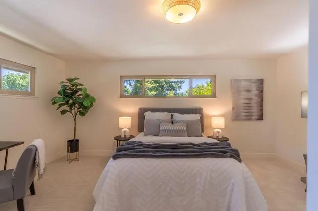 a bedroom with a bed and a potted plant