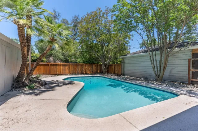 a view of a house with a yard and large tree