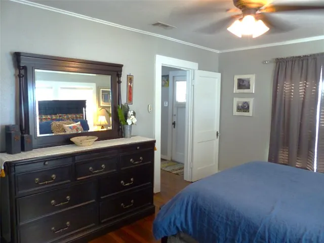 a bedroom with a bed and a mirror on dresser